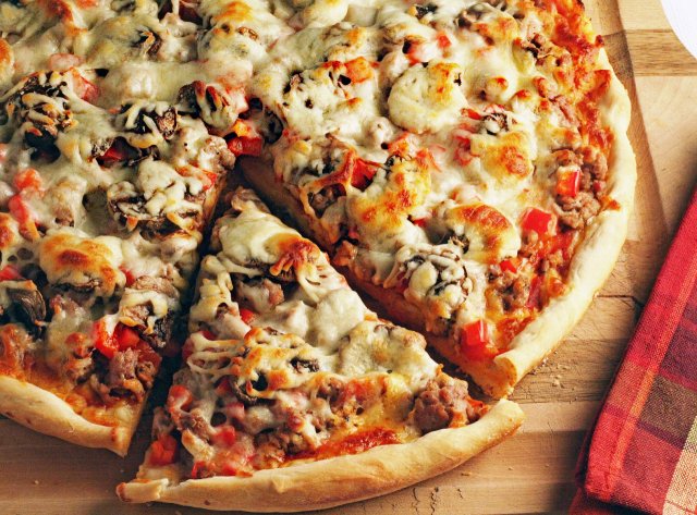Пицца с колбасой, помидорами, грибами и перцем.